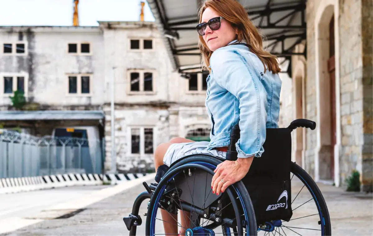 Rödhårig kvinna i en permobilrullstol